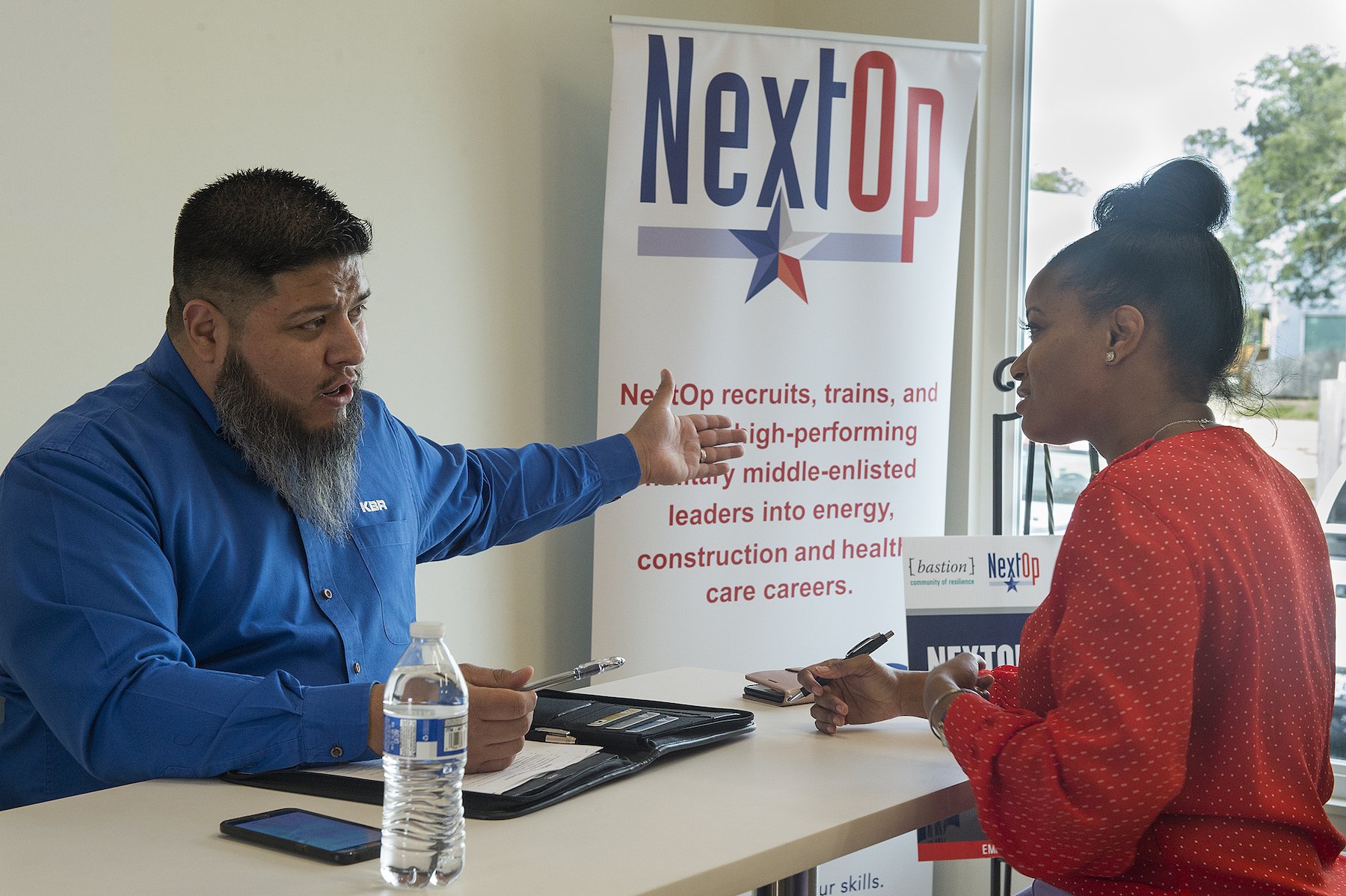 NextOp team member advises veteran about employment services while sitting at a table