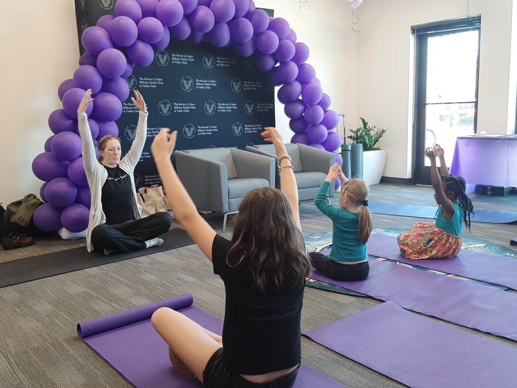 Yoga instructor leads a class of children. 